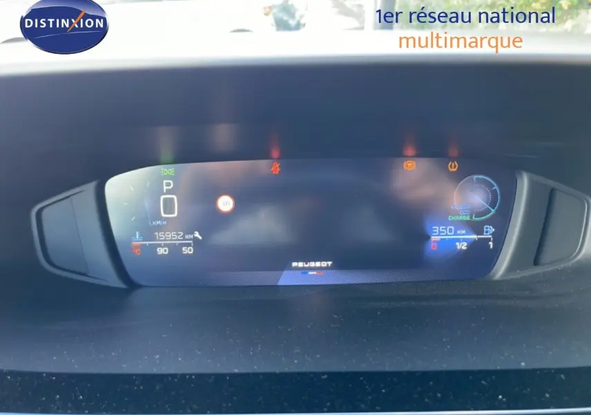 Tableau de bord numérique de Peugeot 308 SW gris, affichant vitesse, autonomie et indicateurs, vue frontale rapprochée.