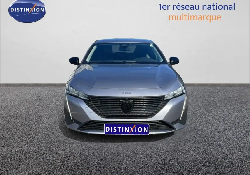 Vue frontale d'une Peugeot 308 SW Hybrid 145ch gris Artense métal, avec calandre noire et feux LED distinctifs.
