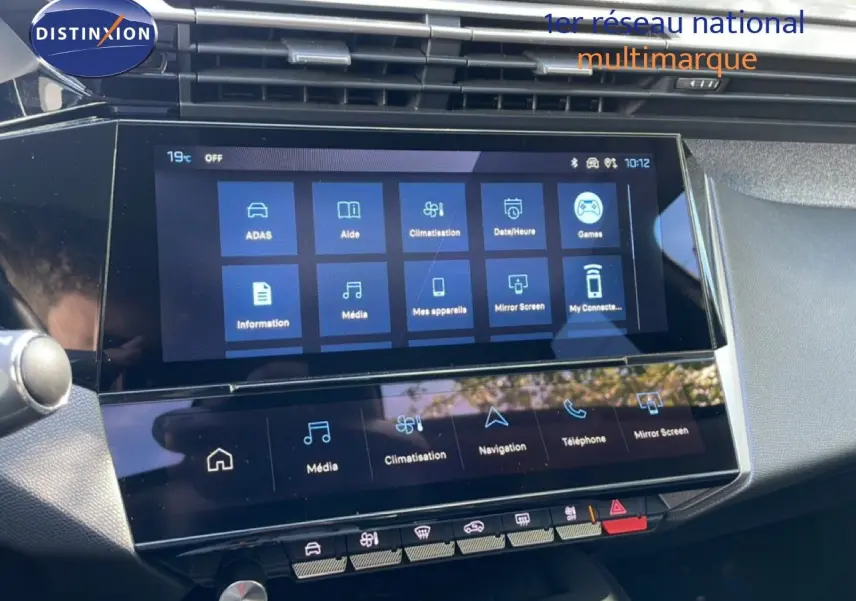 Écran tactile central en gros plan dans l’habitacle gris noir du Peugeot 308 SW Hybrid 2025, affichant les options multimédia et climatisation.