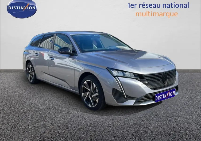 Peugeot 308 SW gris Artense métal vue 3/4 avant droit, avec calandre noire et jantes alliage bicolores.