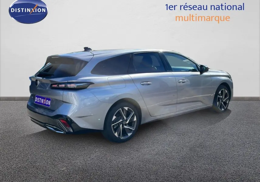 Vue 3/4 arrière droite d'une Peugeot 308 SW Hybrid 145ch gris Artense métallisé avec vitres teintées et jantes alliage.
