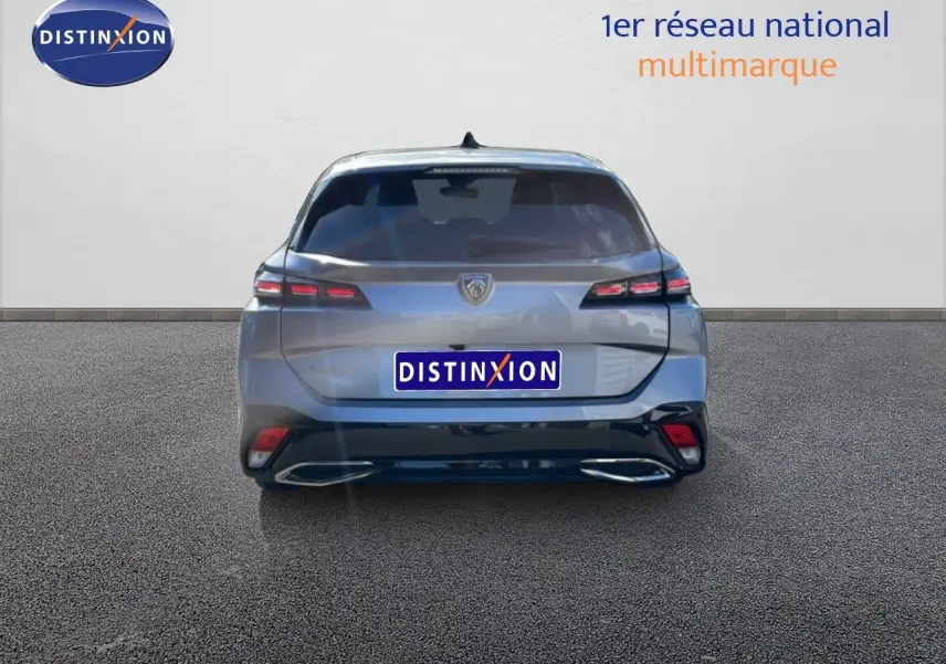Vue arrière d'une Peugeot 308 SW Hybrid 145ch gris Artense métal, avec feux LED et double sortie d'échappement intégrée.