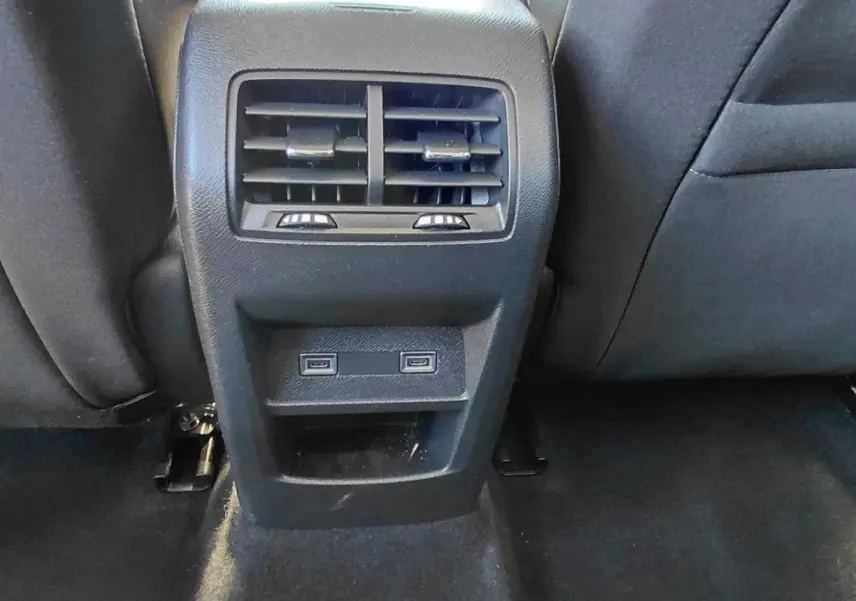 Vue rapprochée de la console arrière avec bouches d’aération et ports USB dans une Peugeot 308 Hybrid 145 gris.