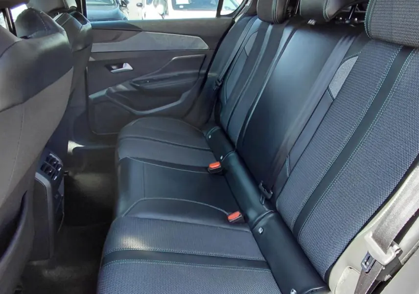 Vue intérieure des sièges arrière en tissu et cuir noir de la Peugeot 308 Hybrid 145 e-DCS6 Allure 2025.