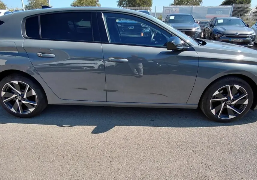 Peugeot 308 Hybrid gris vue de profil côté gauche, avec jantes alliage 17 pouces et vitres teintées.