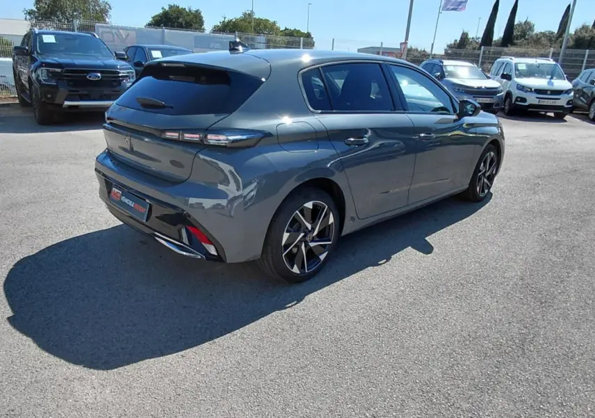 Peugeot 308 gris en 3/4 arrière droit, avec jantes alliage 17 pouces et feux arrière LED distinctifs.