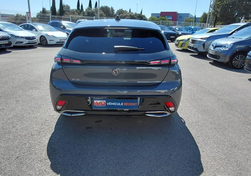 Vue arrière d'une Peugeot 308 gris foncé 2025 avec feux LED et double sortie d'échappement chromée.