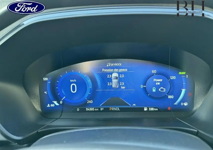 Vue rapprochée du tableau de bord numérique bleu du Ford Kuga 2023 affichant la pression des pneus et la puissance en kW.
