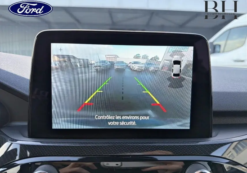 Écran tactile de caméra de recul du Ford Kuga 2023 montrant l’arrière avec guidage coloré, intérieur noir.