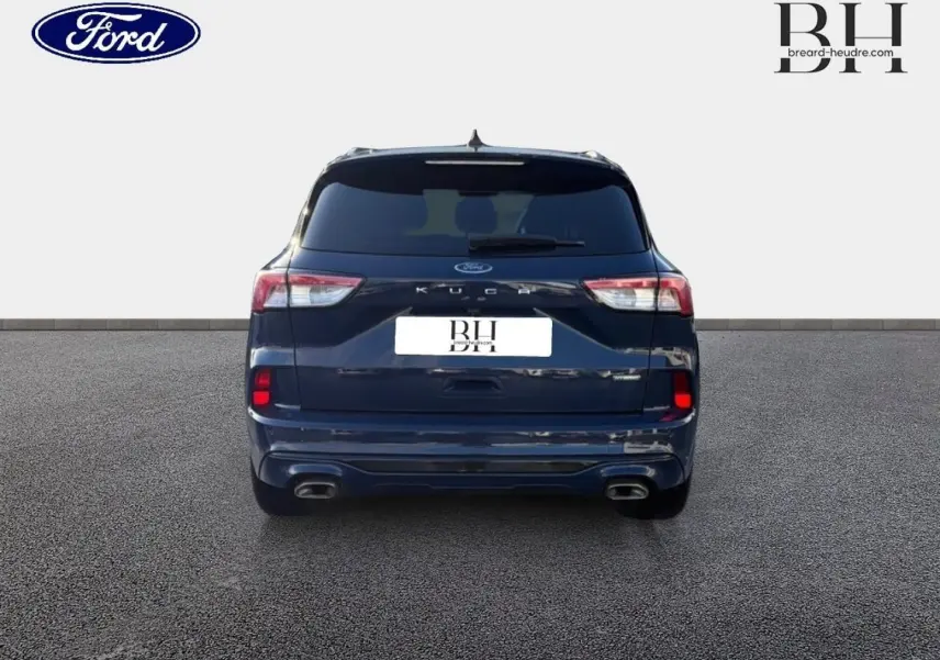 Vue arrière du Ford Kuga bleu Abysse 2023 avec double sortie d’échappement et lunette arrière surteintée.