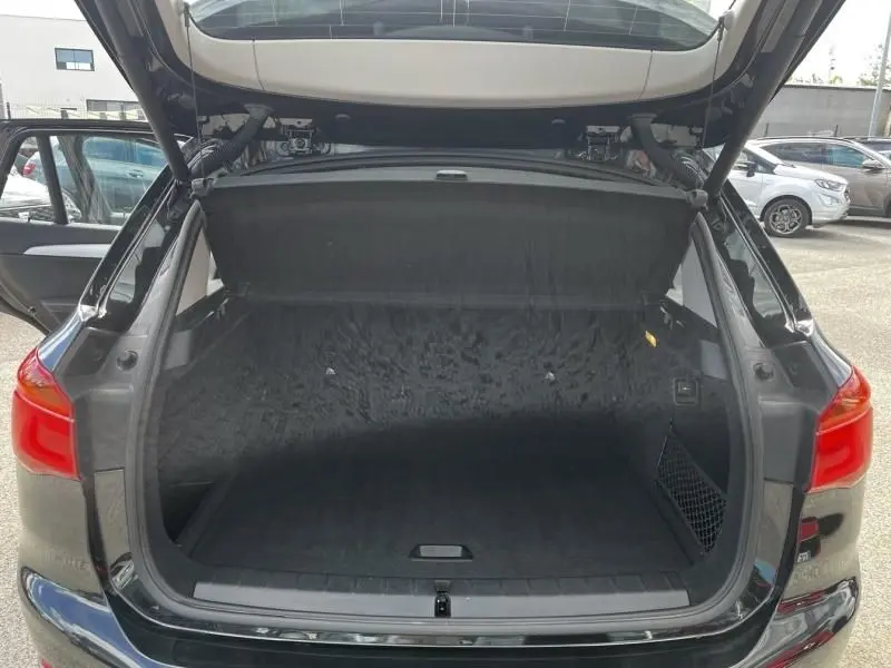 Coffre ouvert vu de l'arrière d'un BMW X1 noir métal 2017, montrant un espace de chargement vide et propre.