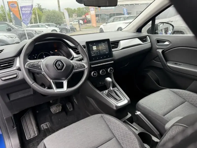 Vue intérieure avant du Renault Captur E-Tech 145 Zen 2022, tableau de bord moderne avec écran tactile et volant multifonction.