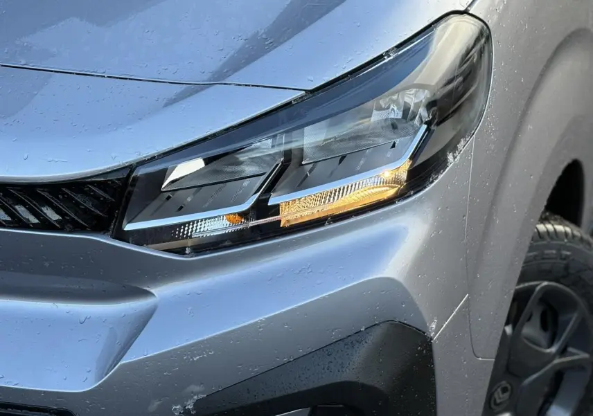 Gros plan sur le phare avant droit gris Artense du Citroën Jumpy XL 2025 avec détails du bouclier noir Perla Nera.