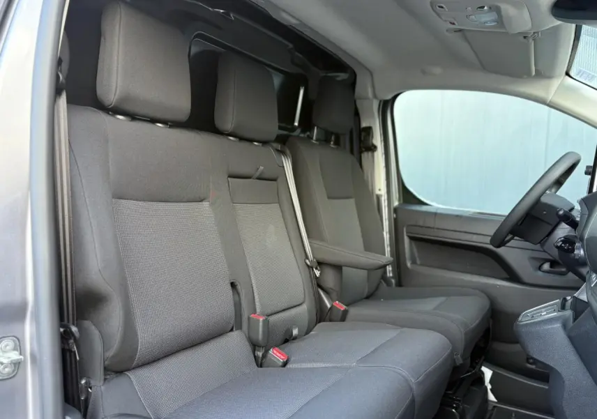 Intérieur du Citroën Jumpy XL 2025 en gris, vue latérale des sièges avant et banquette passager double.