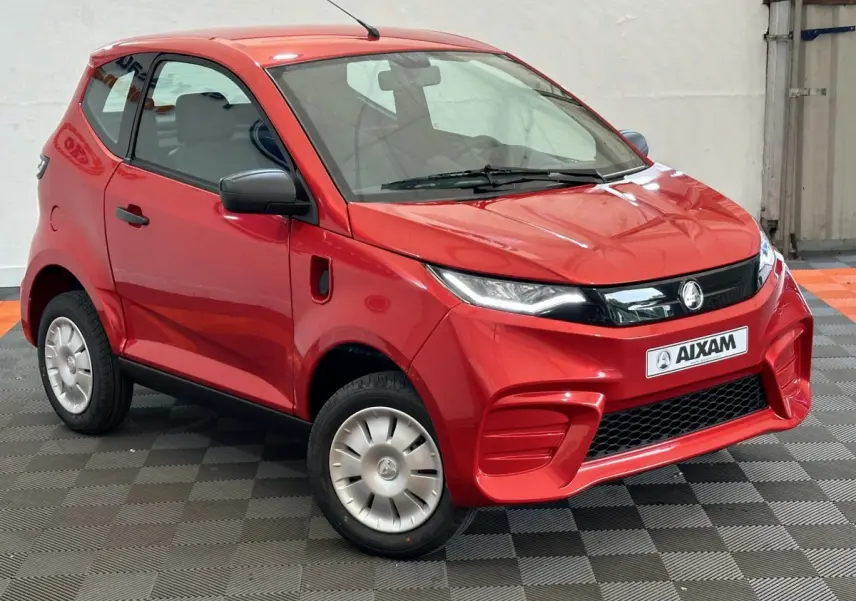 Vue 3/4 avant d'une Aixam Ambition E City Pack rouge 2025 avec rétroviseur caméra côté gauche.