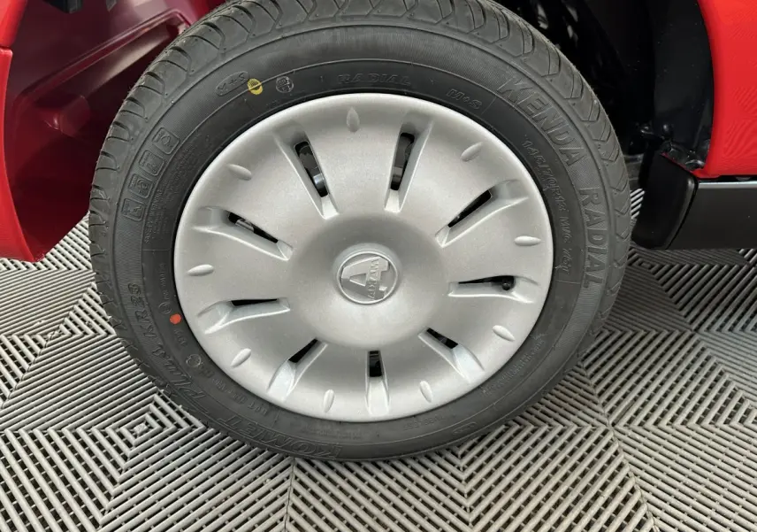 Gros plan sur la roue avant gauche de l'AIXAM Ambition E City Pack rouge 2025 avec enjoliveur gris et pneu radial.