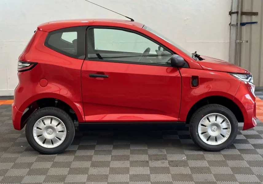Profil côté gauche de l'AIXAM AMBITION E CITY PACK rouge 2025, citadine électrique compacte avec rétroviseur caméra.