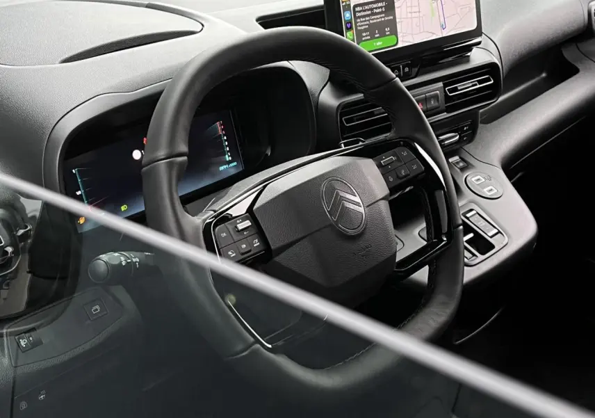 Vue rapprochée de l’intérieur du Citroën Berlingo Multispace 2025, volant multifonctions cuir et écran tactile couleur.