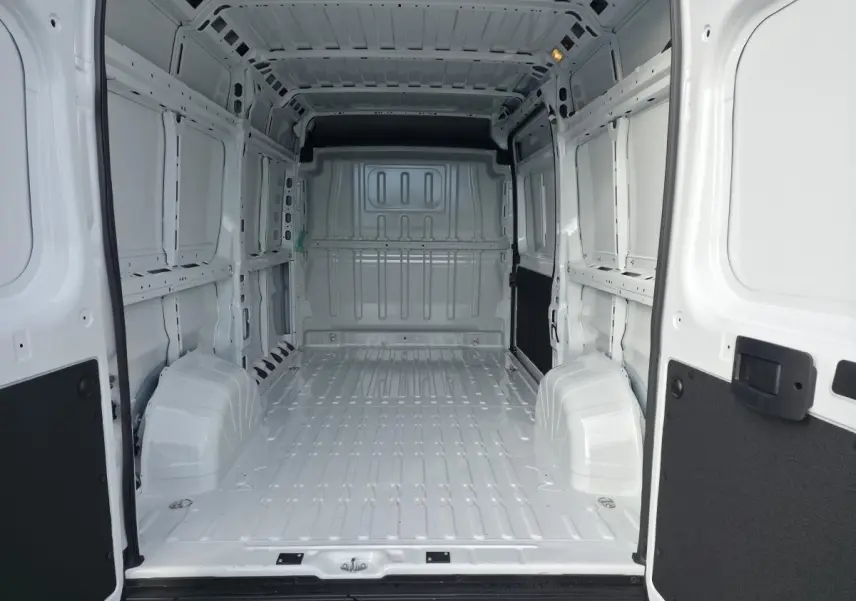 Vue intérieure arrière du fourgon FIAT Ducato blanc tôlé, montrant l'espace de chargement vide et les parois métalliques.