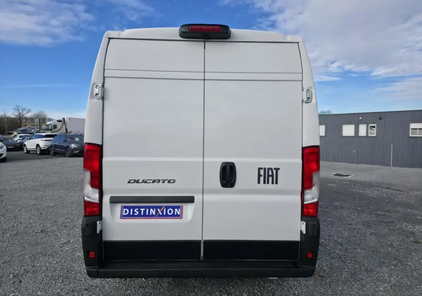 Vue arrière d’un FIAT Ducato Fourgon blanc 2025 avec portes tôlées et feux arrière rouges visibles.