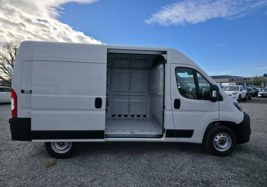 Vue latérale droite d'un FIAT Ducato Fourgon blanc 2025 avec porte coulissante ouverte montrant l'intérieur tôlé vide.