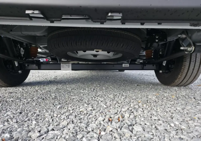 Vue en contre-plongée sous le Fiat Ducato Fourgon blanc, mettant en valeur la roue de secours et le châssis arrière.