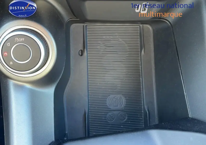 Gros plan sur la console centrale noire de l'Alfa Romeo Tonale 2025 avec zone de recharge sans fil et molette de sélection.