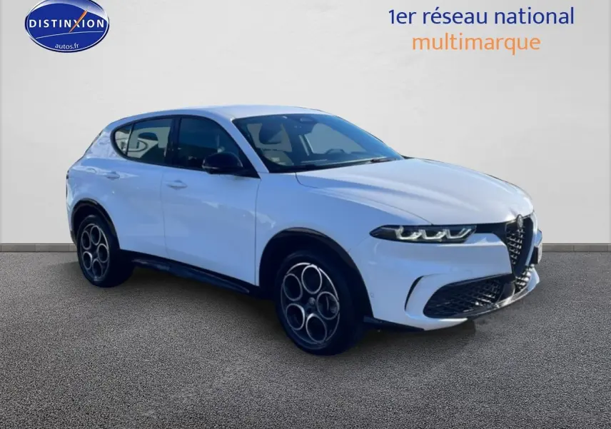 Vue 3/4 avant droite d’un Alfa Romeo Tonale blanc 2025 avec jantes alu et calandre distinctive en V.