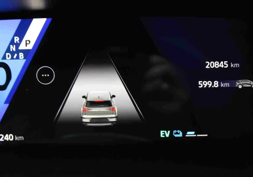 Affichage numérique du tableau de bord montrant un véhicule blanc vu de l'arrière en mode hybride avec compteur à zéro.