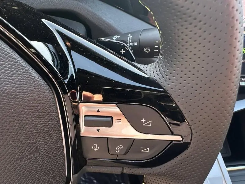 Gros plan sur les commandes vocales et téléphone sur le côté gauche du volant perforé de la Peugeot 308 2025.