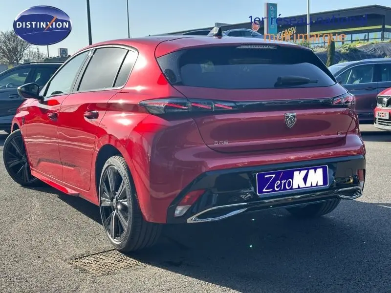 Vue 3/4 arrière droite d'une Peugeot 308 rouge Elixir avec feux arrière LED et jantes alliage noires.
