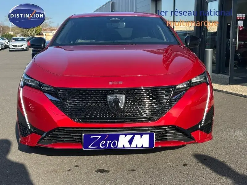 Vue frontale d'une Peugeot 308 rouge Elixir avec calandre noire et phares LED distinctifs.