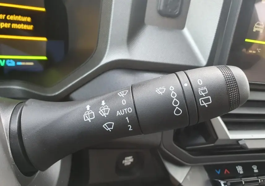 Gros plan sur la commande des essuie-glaces du tableau de bord du Dacia Bigster gris schiste, intérieur moderne.