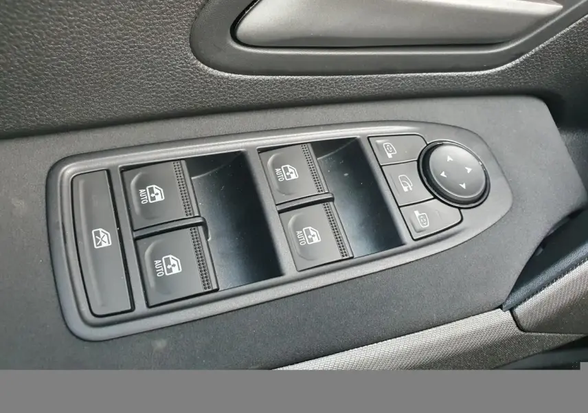 Gros plan sur les commandes de lève-vitres et rétroviseurs côté gauche intérieur du Dacia Bigster gris schiste 2026.