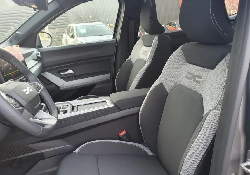 Intérieur de la Dacia Bigster 2026 en gris schiste, vue côté conducteur sur sièges sport bicolores et tableau de bord moderne.