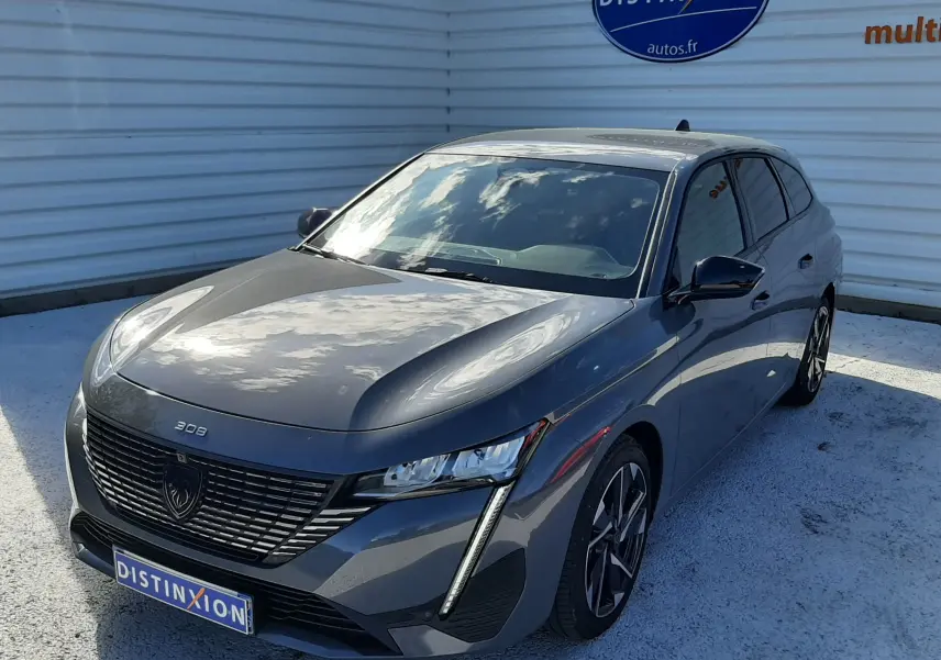 Peugeot 308 SW Hybrid gris sélénium métal vue 3/4 avant droit, avec calandre noire et feux LED verticaux distinctifs.