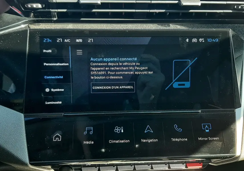 Vue rapprochée de l’écran tactile central noir du tableau de bord de la Peugeot 308 SW Hybrid gris Selenium, affichant le menu connectivité.