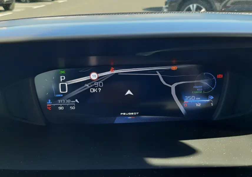 Tableau de bord numérique de Peugeot 308 SW Hybrid 2025 affichant la navigation et l'autonomie à 350 km.