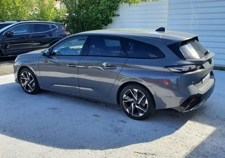Peugeot 308 SW gris Selenium métal vue 3/4 arrière droit, avec jantes alliage et feux arrière LED distinctifs.