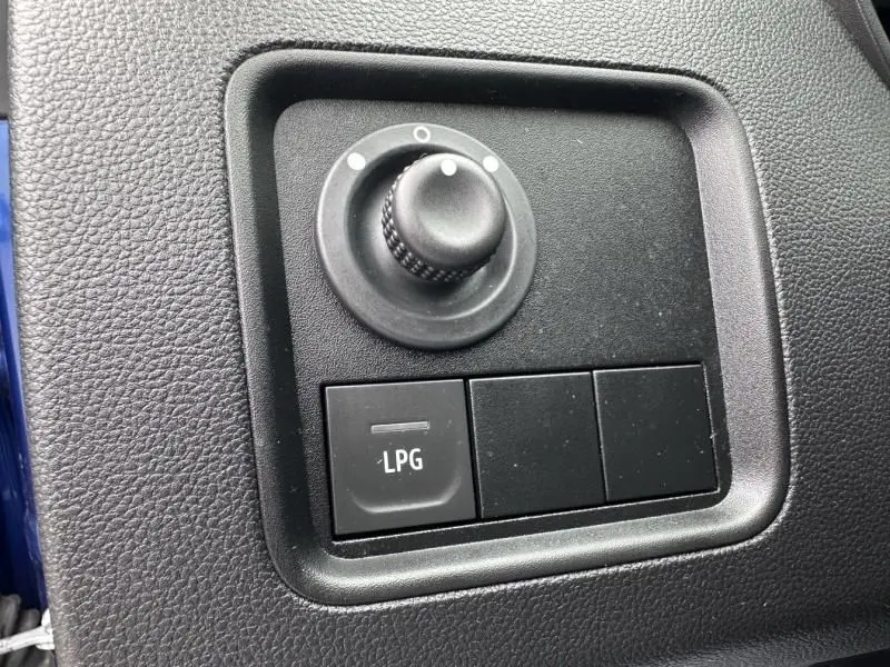 Gros plan sur le bouton de commande LPG et le réglage des rétroviseurs dans l’habitacle du Dacia Duster bleu métal 2022.