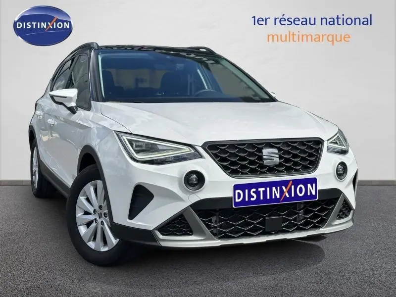 SEAT Arona blanc Candy avec toit noir Minuit, vue 3/4 avant, calandre noire et jantes alu visibles.