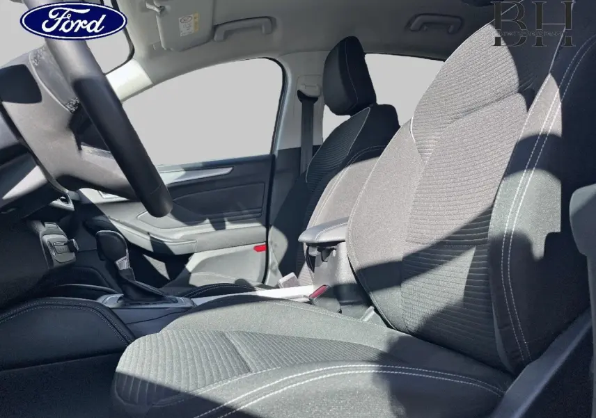 Intérieur de la Ford Focus 2022, vue côté droit sur les sièges tissu noir avec coutures blanches et accoudoir central.