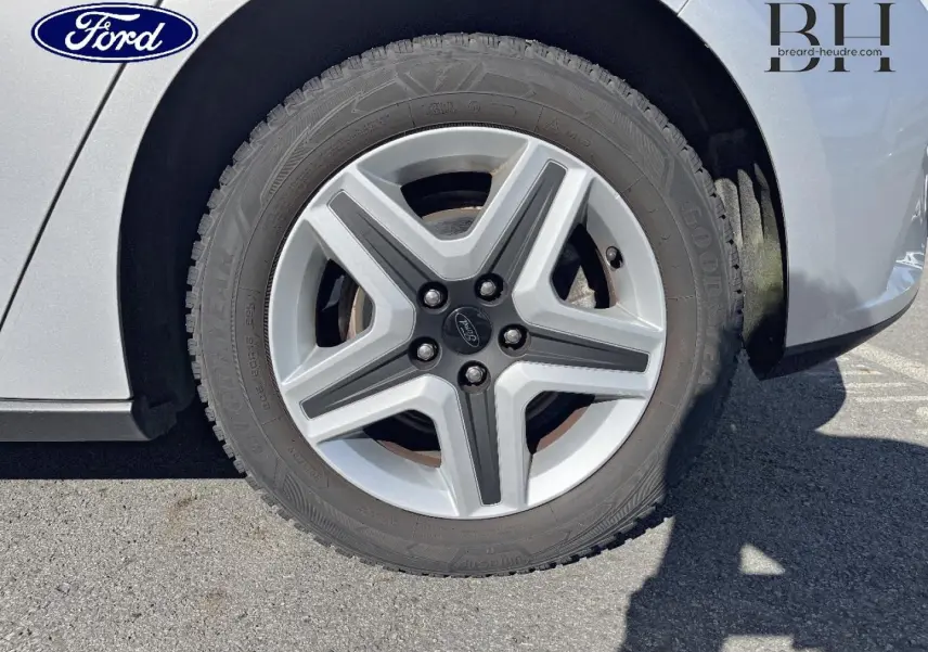 Gros plan sur la roue avant droite d'une Ford Focus gris lunaire métallisé avec jante alliage à cinq branches.