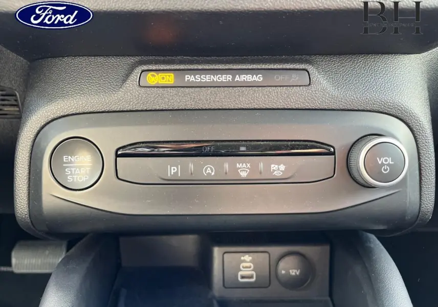 Vue rapprochée du tableau de bord central de la Ford Focus gris lunaire, avec bouton start/stop et commandes audio.