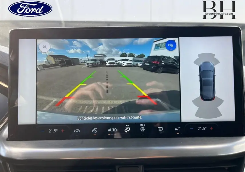 Écran tactile intérieur montrant la caméra de recul et l’aide au stationnement de la Ford Focus gris lunaire métallisé.