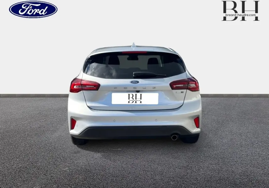 Vue arrière d'une Ford Focus gris lunaire métallisé 2022 avec feux rouges et lunette arrière surteintée.