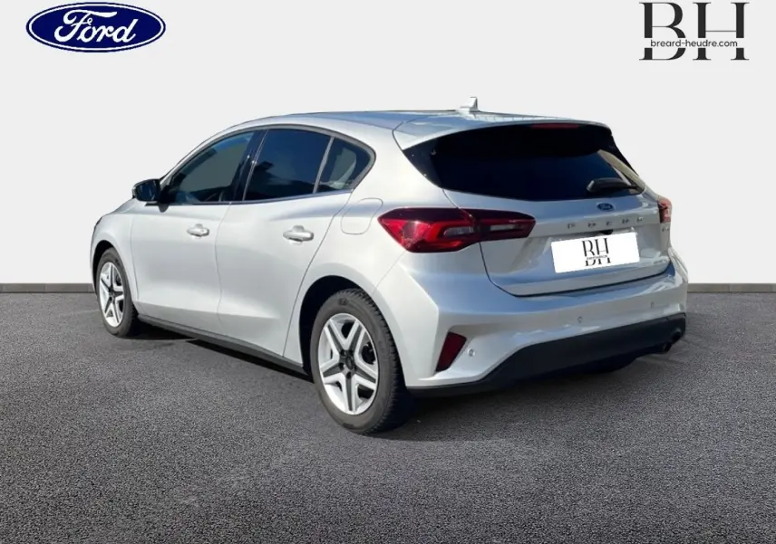 Vue 3/4 arrière droite d'une Ford Focus gris lunaire métallisé avec vitres arrière surteintées et feux arrière LED distinctifs.