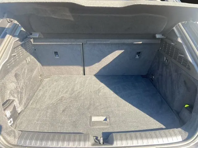 Coffre ouvert de l'Audi A3 Sportback gris Manhattan, vue intérieure montrant l'espace de chargement propre et spacieux.