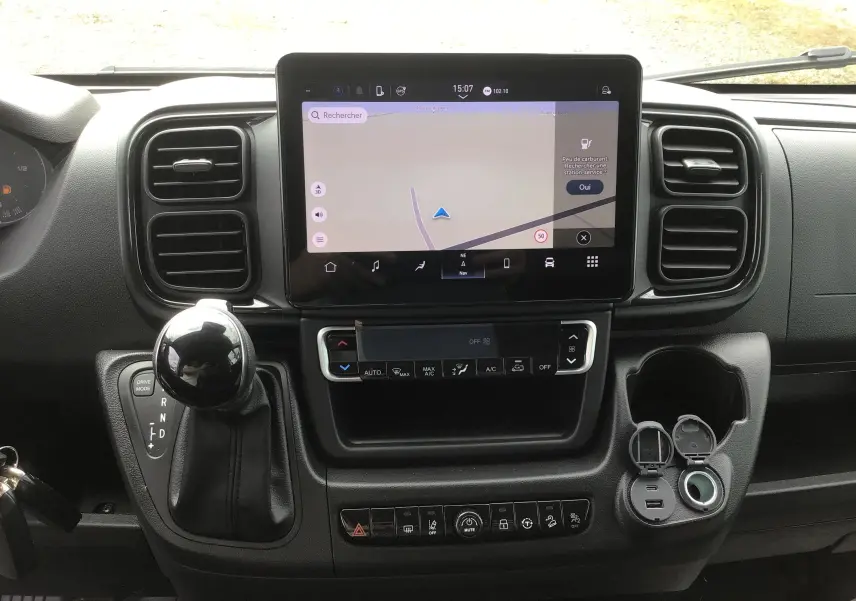 Tableau de bord du Peugeot Boxer Fourgon 2025 en vue frontale, avec écran tactile de navigation et levier de vitesses noir.