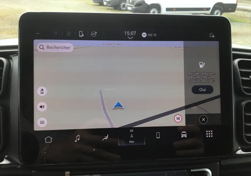 Écran tactile du système de navigation du Peugeot Boxer Fourgon blanc, affichant une carte et une alerte de faible carburant.
